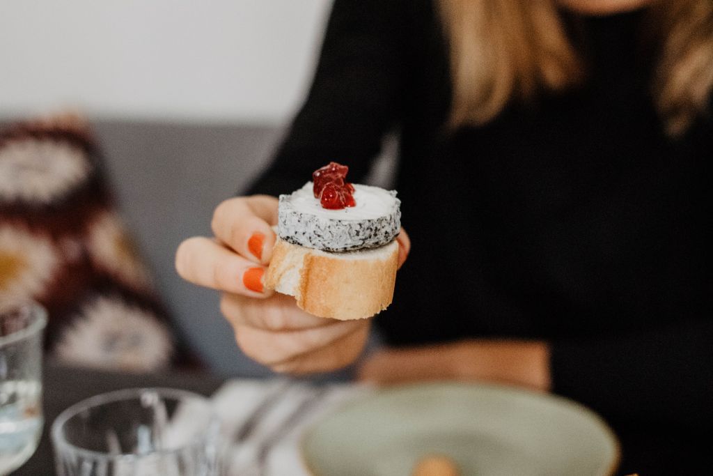 Eine Scheibe Baguette mit Käse und Preiselbeeren